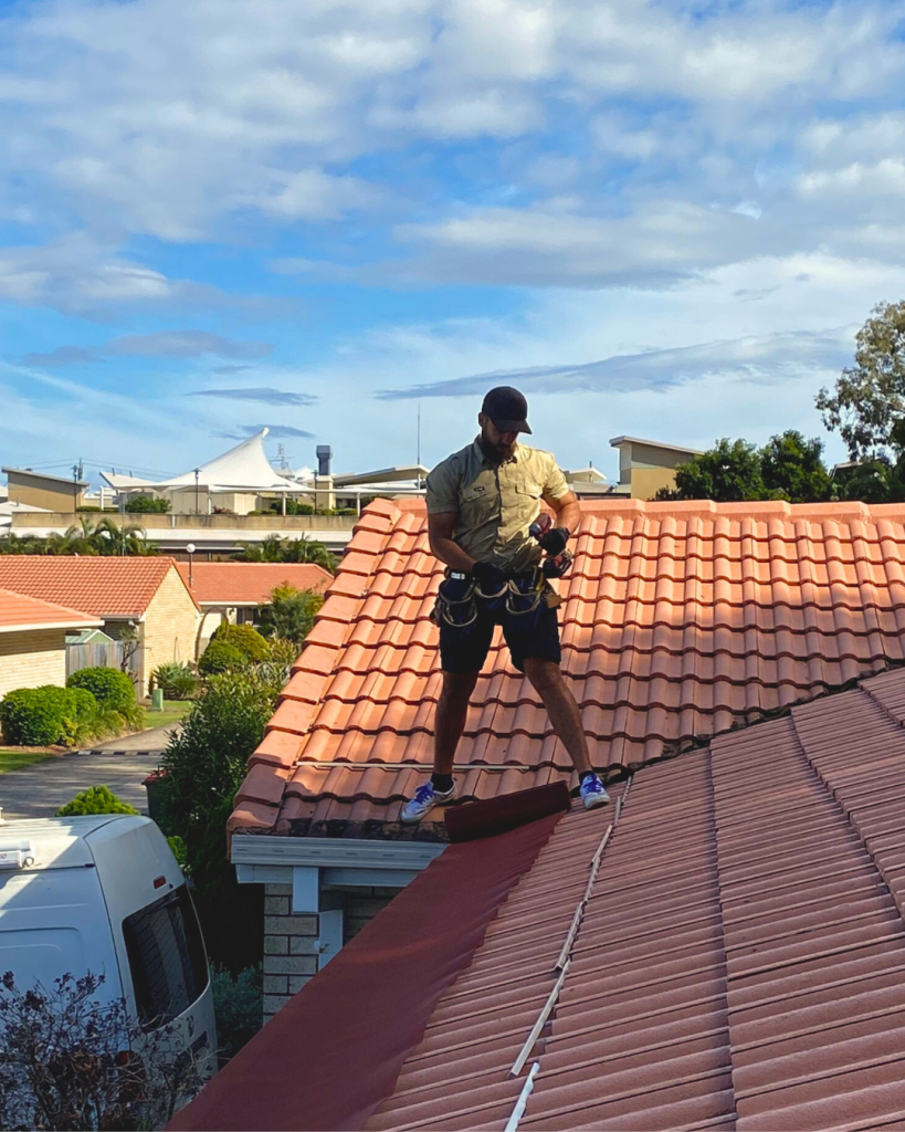 Worker preparing ember guard roll on rooftop edge