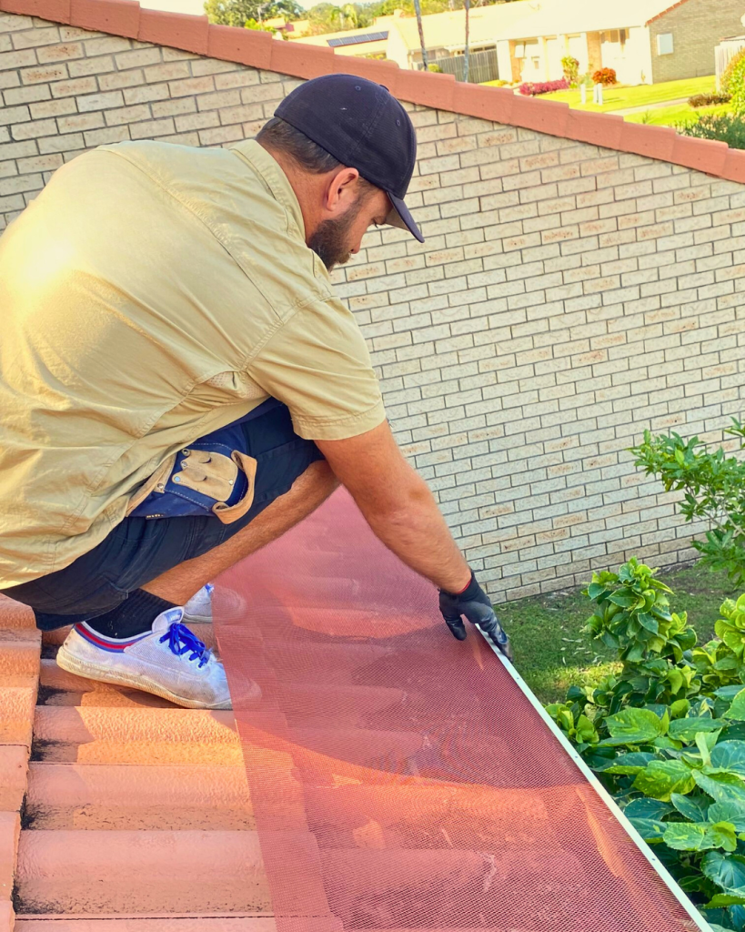 Close-up of ember guard mesh being aligned on roof gutter