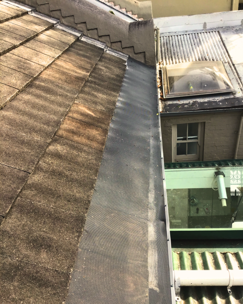 Ember guard installed on a metal roof corner near skylight