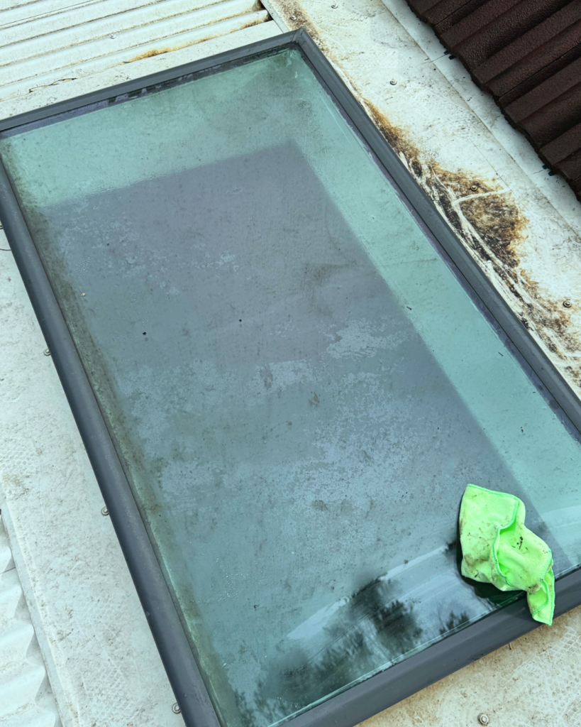 Dirty skylight with cloth mid-clean during skylight