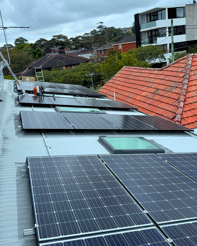 Rooftop solar panels installed with bird-proof mesh around the edges.