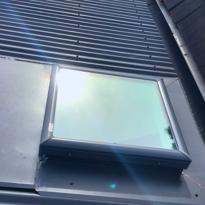 Clean skylight on corrugated roof reflecting sunlight.